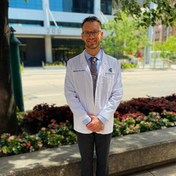 Nathan Meyette posed in his white coat outside.